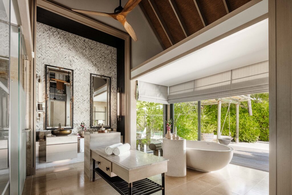 Modernes Badezimmer mit freistehender Badewanne, Doppelwaschbecken und großer Fensterfront zur grünen Landschaft