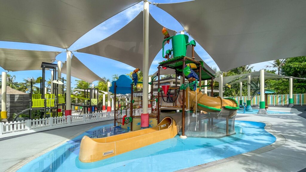 Wasserspielplatz mit bunten Papageienfiguren, Segeltuchüberdachungen und rutschfestem Boden im Waldorf Astoria Maldives.