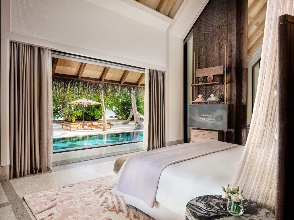 Hotelzimmer mit großem Bett, taupefarbenen Vorhängen, Terrasse und Pool bei Joali Maldives auf den