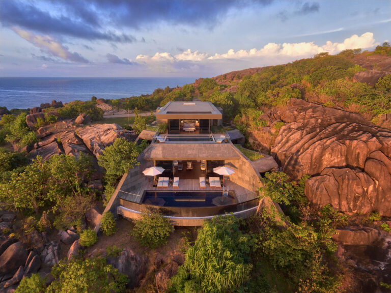 Luftaufnahme des Six Senses Zil Pasyon mit mehrstöckigem Gebäude, Pool, Terrassen und felsiger Vegetation auf den