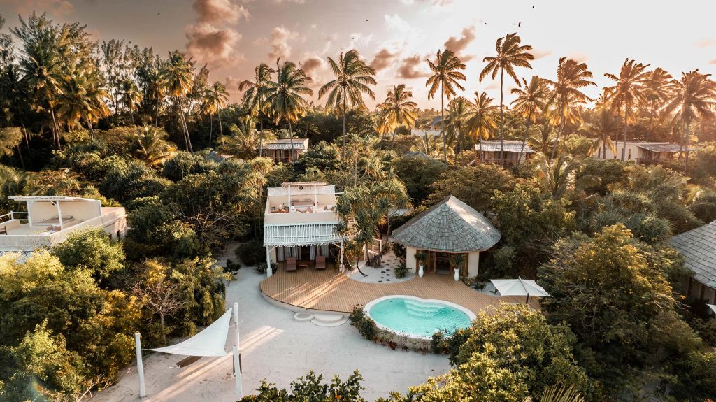 Luftbild einer tropischen Resort mit rundem Pool, Holzdeck und umgeben von grüner Vegetation auf Sansibar