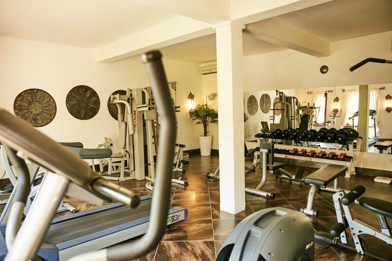 Fitnessraum im Baraza Resort & Spa mit Laufbändern, Hanteln, Spiegel und Tageslichtfenstern