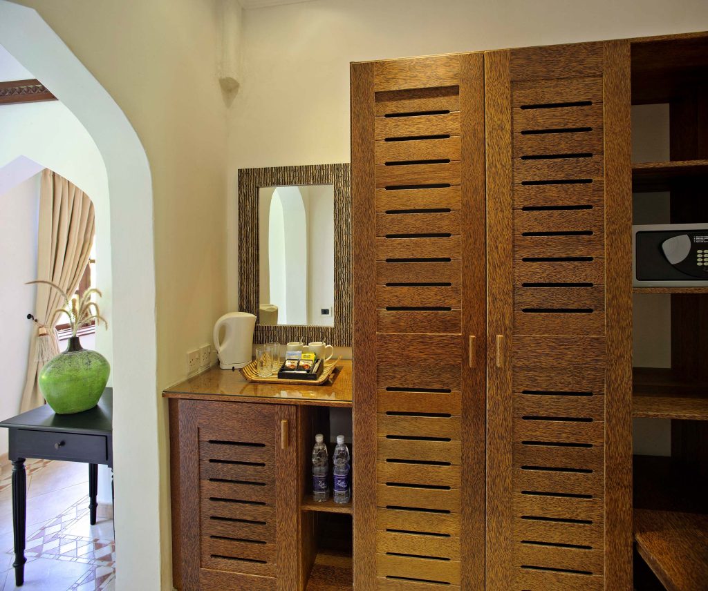 Einbauschrank und Anrichte aus dunklem Holz mit Wasserkocher, Safe und Spiegel