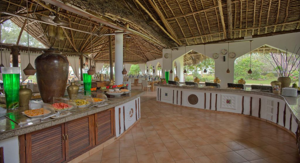 Offenes Restaurant mit Buffet und Essbereich unter Strohdach im Bluebay Beach Resort & Spa auf Sansibar