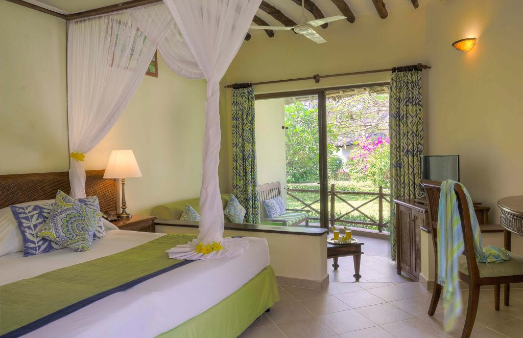Hotelzimmer mit Himmelbett, weißen Vorhängen, Holzbalkendecke und Terrasse mit Gartenmöbeln im Sultan Sands Island Resort