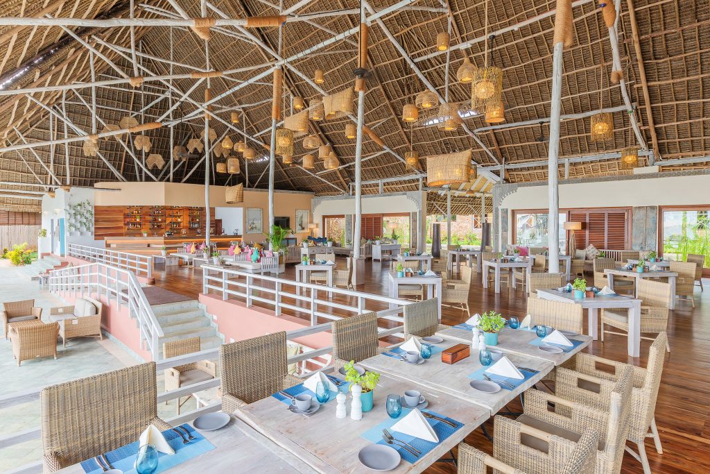 Offener Essbereich im Melia Zanzibar mit hohen Holzbalken, Strohdach, hellen Holzmöbeln