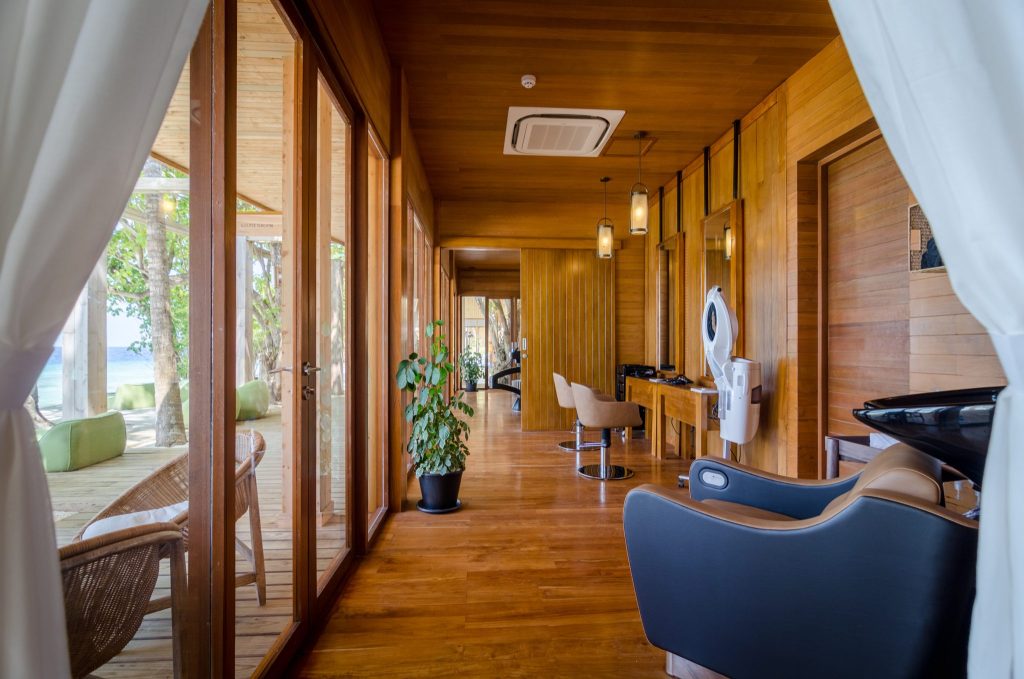 Holzverkleideter Wellnessraum im Javvu Spa mit modernen Friseurstuhl und großen Glasfenstern zur Terrasse