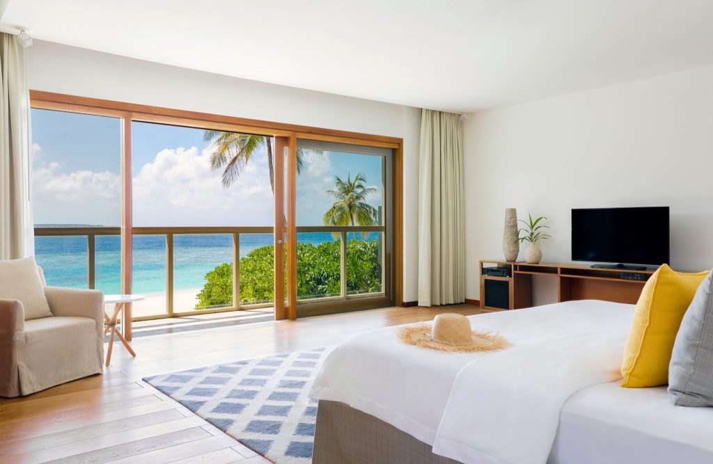 Hotelzimmer der Private Beach Residence Amilla Maldives mit Doppelbett, Fensterfront und Meerblick
