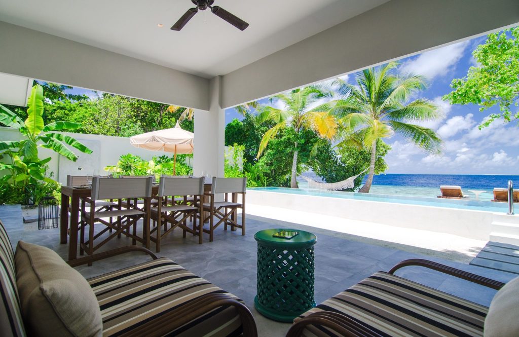 Offene Terrasse der Two Bedroom Beach Pool Villa mit Liegestühlen, Hängematte, Holztisch und Meerblick auf den