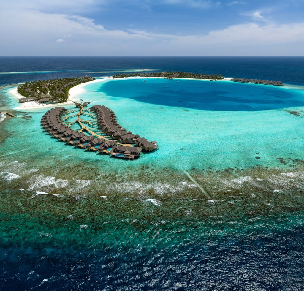 Luftaufnahme der Überwasserbungalows von ananea Madivaru Maldives mit türkisblauem Ozean und grüner Inselvegetation