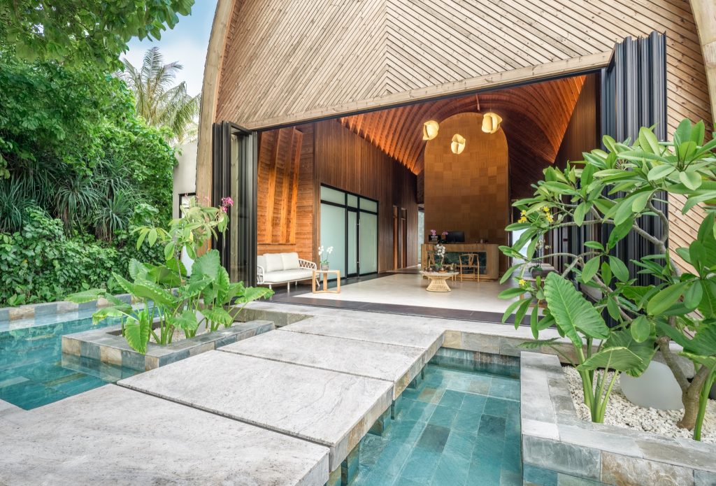 Eingang eines modernen Hotelbungalows mit Holzstruktur, Glasfalttüren und kleinem Pool im ananea Madivaru Maldives