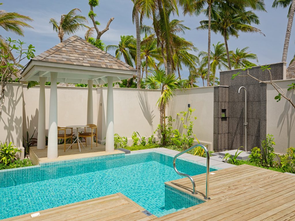 Private Terrasse der 2BR Beach Residence mit kleinem Pool, Holzplattform, Pavillon und Palmen auf den