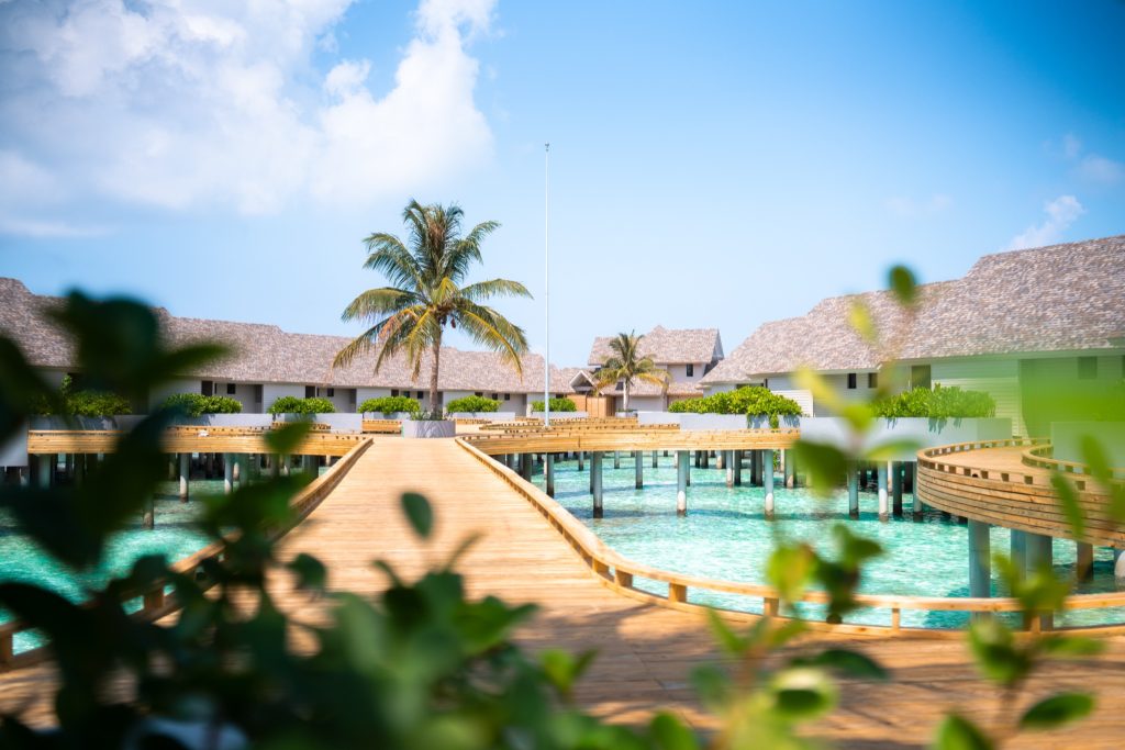 Water Pool Villa ananea Madivaru Maldives auf Stelzen mit hölzernem Steg und Strohdächern über türkisfarbenem Wasser