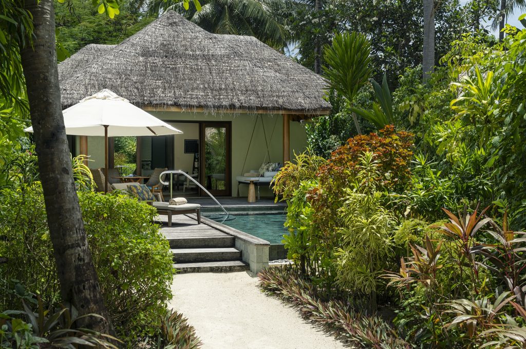 Baros Residence Bungalow mit Strohdach, grünem Anstrich, privatem Pool und Sitzmöbeln in tropischem Garten