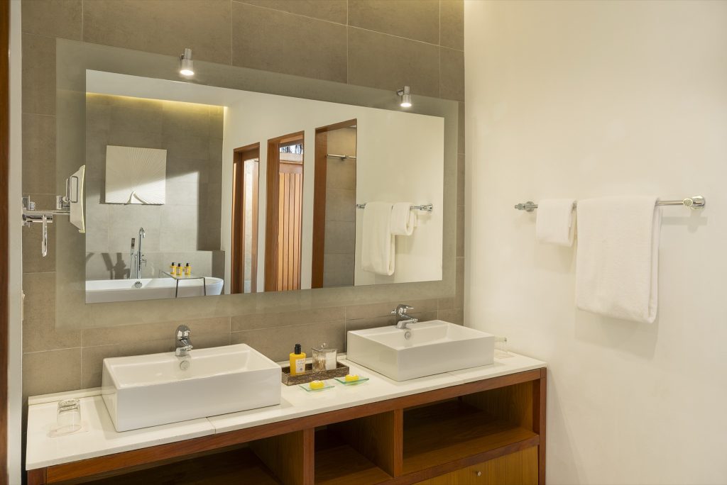 Modernes Badezimmer der Baros Villa mit zwei rechteckigen Waschbecken, Marmorarbeitsplatte und großem Wandspiegel
