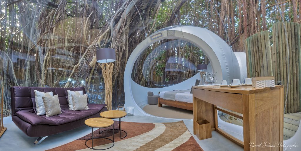 Zimmer Banyan Tree mit transparentem Dach und Wänden, Sofa, Holztisch und Blick auf dichten Wald in Mauritius