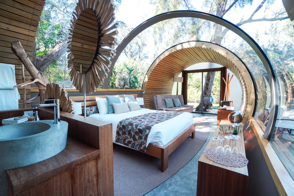 Modernes Zimmer der Bubble Lodge Île aux Cerfs eco-lodge mit bogenförmigen Holzlamellen, Betonwaschbecken und großer Glaswand