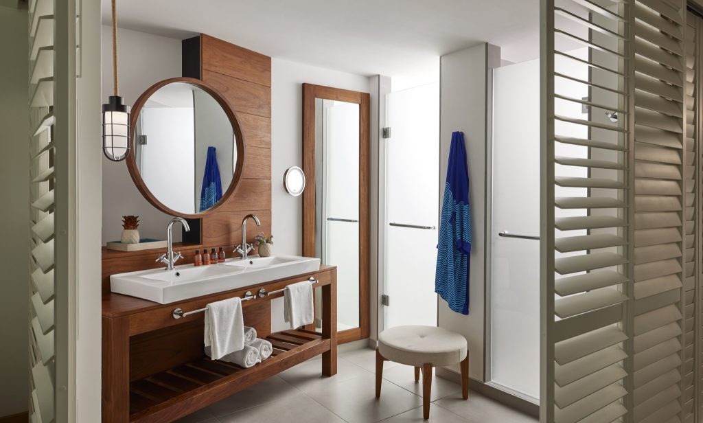 Modernes Badezimmer im deluxe-room mit Holzwaschtisch, Doppelwaschbecken, rundem Spiegel und gläserner Duschkabine
