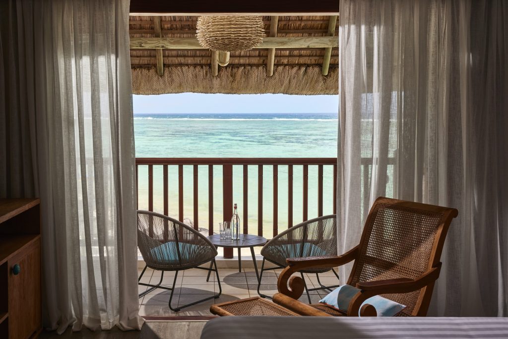 Hotelzimmer Prestige Room mit Holzmöbeln, Balkon mit runden Tisch, zwei Sesseln und direktem Meerblick bei Tageslicht