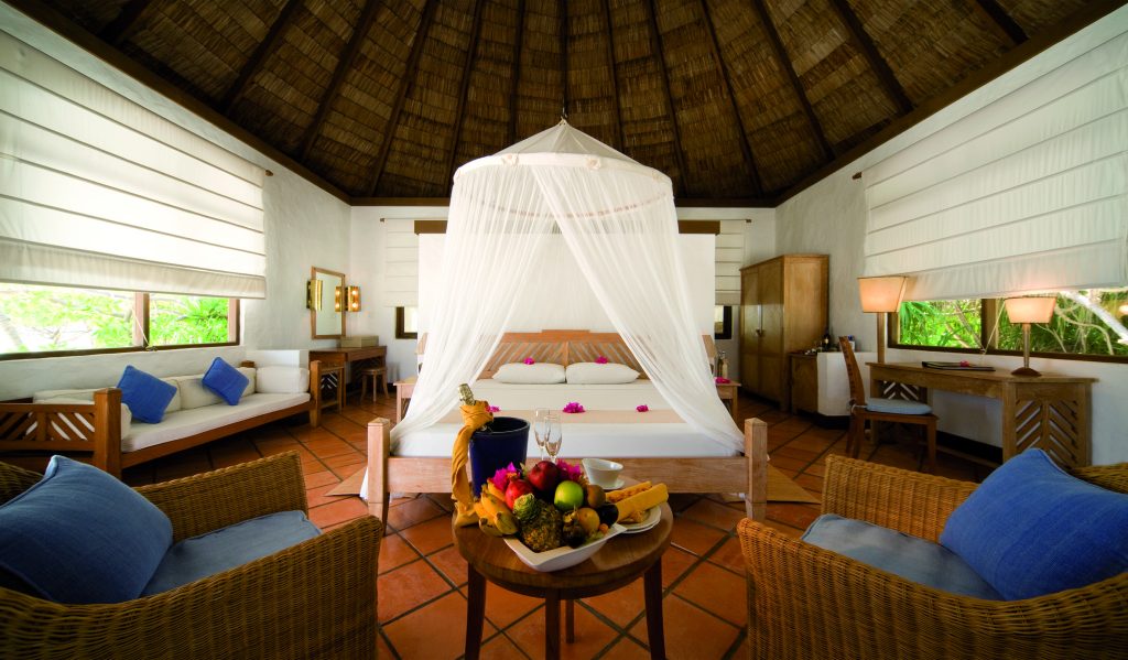 Geräumiges Zimmer der Beach Villa mit Himmelbett, Moskitonetz, terrakottafarbenen Fliesen und großen Fenstern