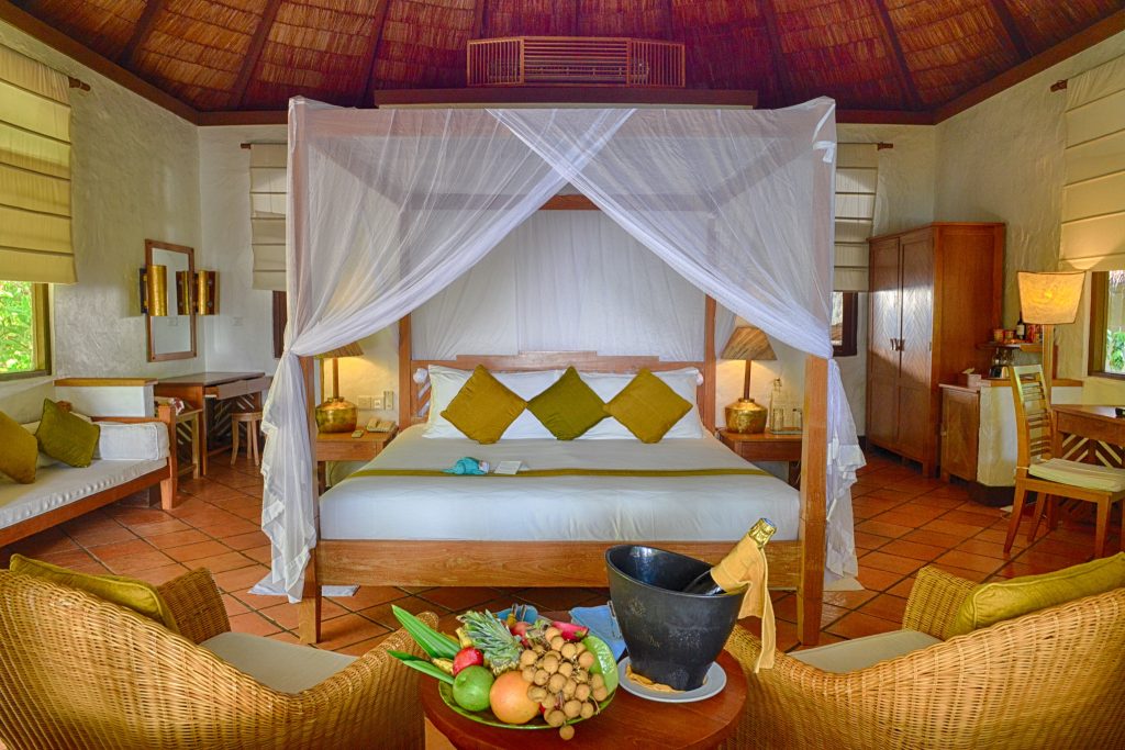 Deluxe Villa Zimmer im Coco Palm Dhuni Kolhu mit Himmelbett, Holzmöbeln, Strohdach