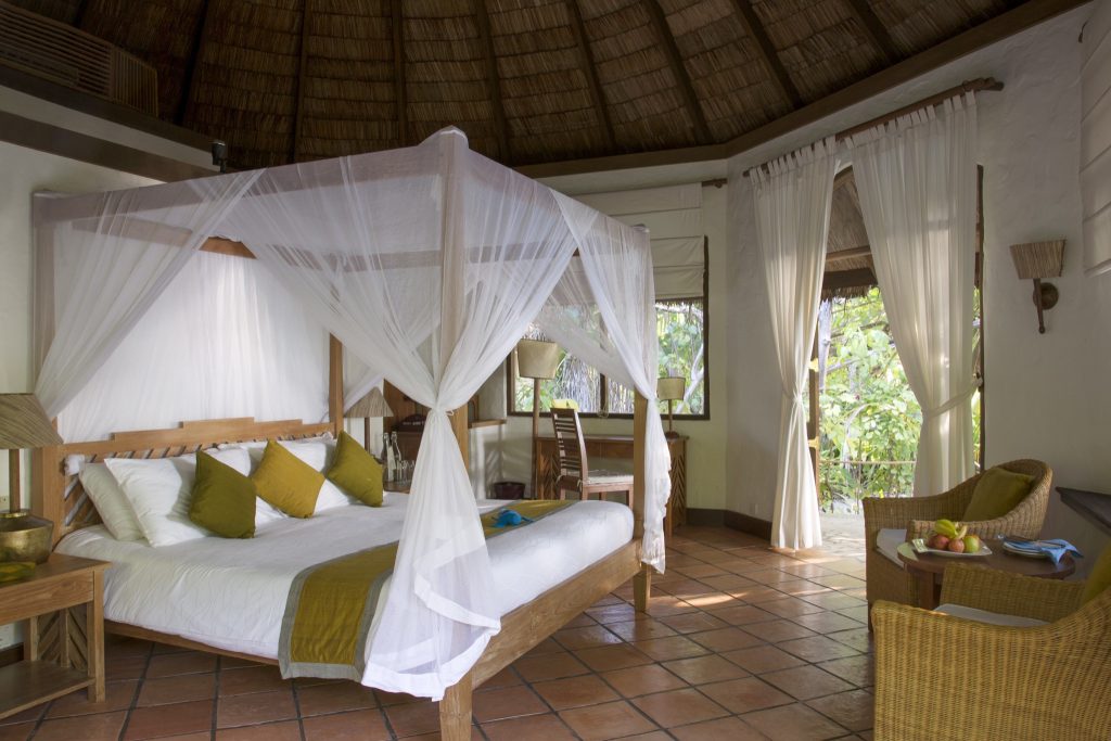 Deluxe Villa Zimmer im Coco Palm Dhuni Kolhu mit Himmelbett, Moskitonetz, Strohbaldachin und Korbmöbeln