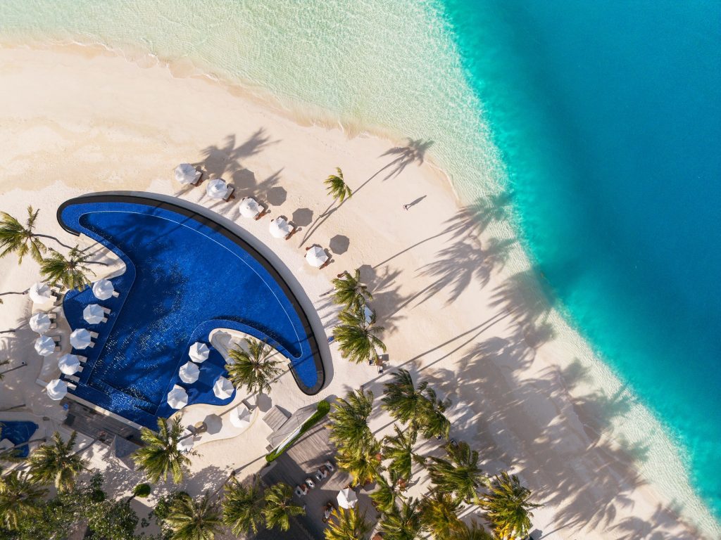 Luftaufnahme des Hauptpools mit umliegenden Villen und türkisfarbenem Wasser auf Conrad Maldives Rangali Island