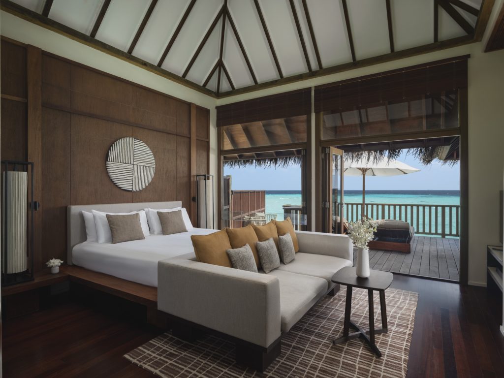 Zimmer der 2BR Grand Water Villa im Conrad Maldives Rangali Island mit großem Bett, Sofa und Meerblick