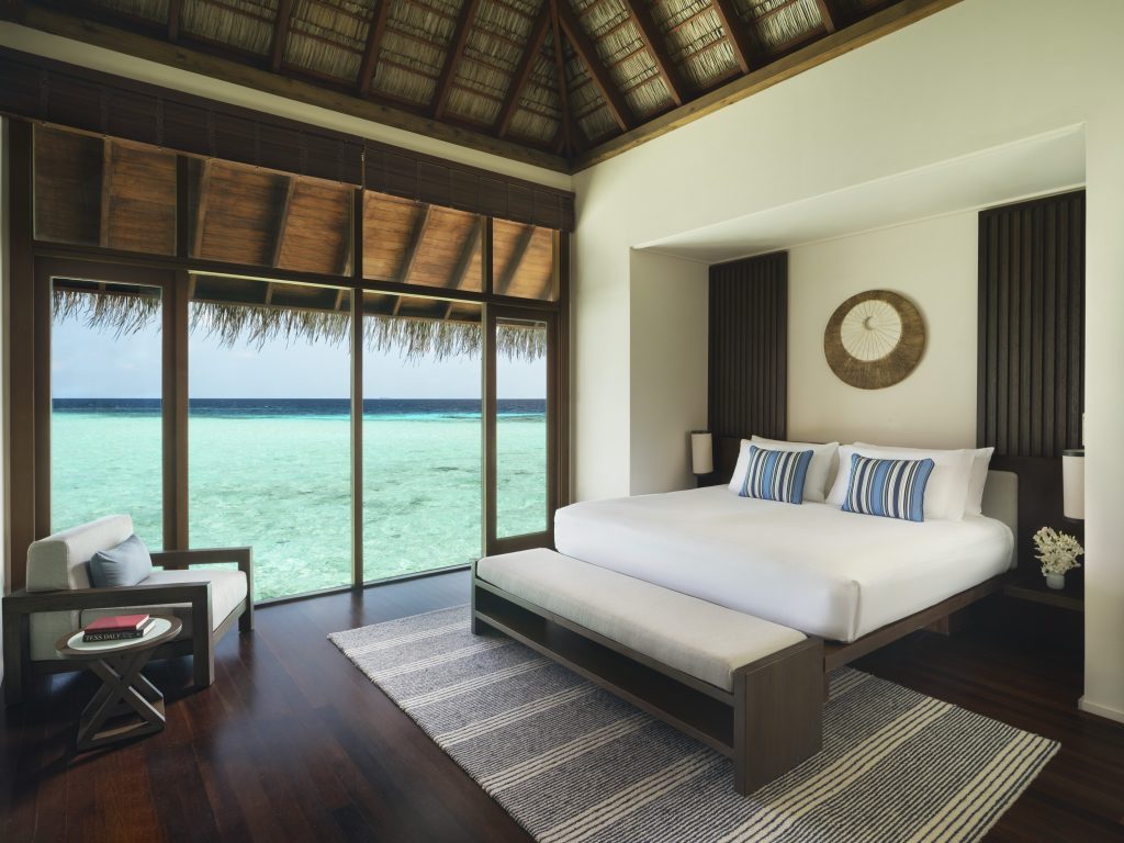 Grand Water Villa Zimmer mit großer Glasfront und Blick auf das türkisfarbene Meer auf den
