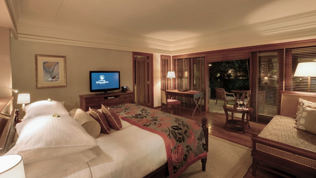 Family Suite im Constance Prince Maurice mit großem Bett, dunklen Holzmöbeln und Balkon mit Sitzgelegenheiten