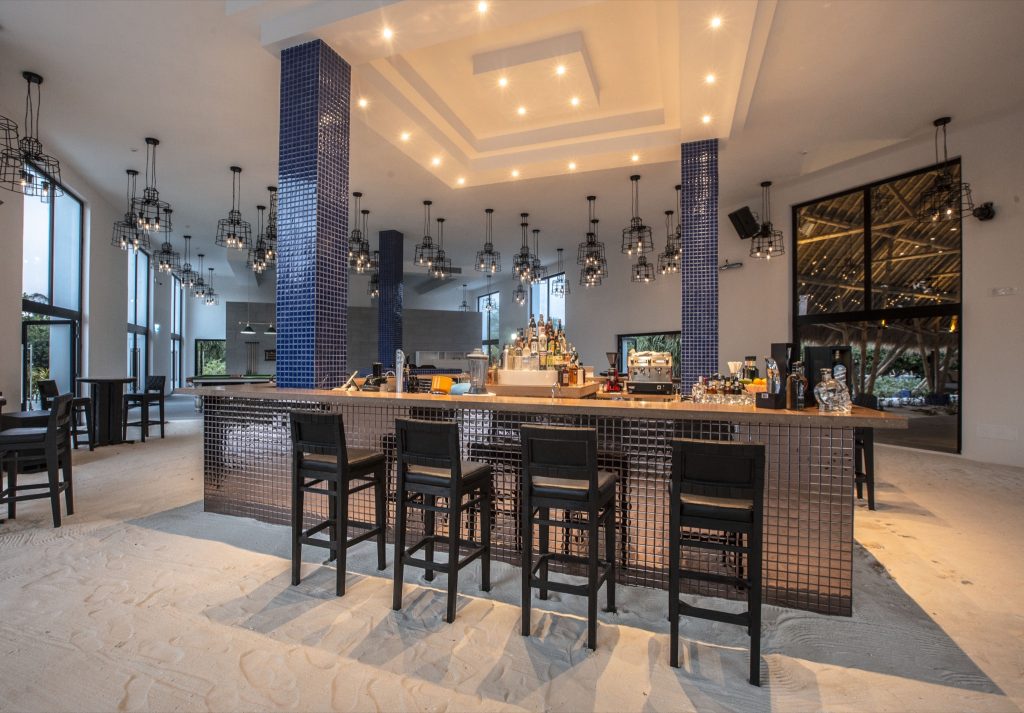 Moderne Hotelbar im Emerald Maldives Resort & Spa mit blauer Fliesen-Theke, schwarzen Barhockern