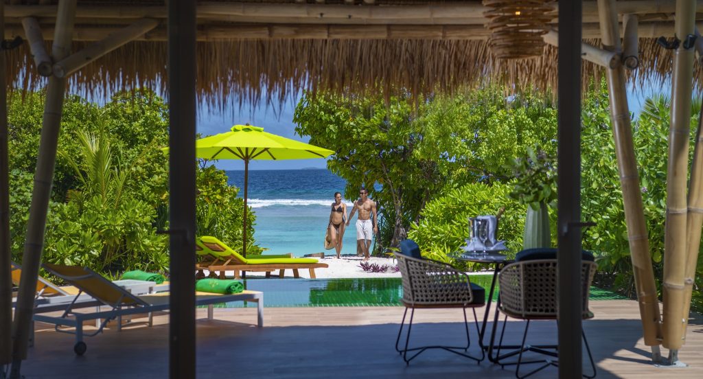 Überdachter Außenbereich mit Holzmöbeln, Bambus, Strandzugang und Meerblick im Emerald Maldives Resort & Spa