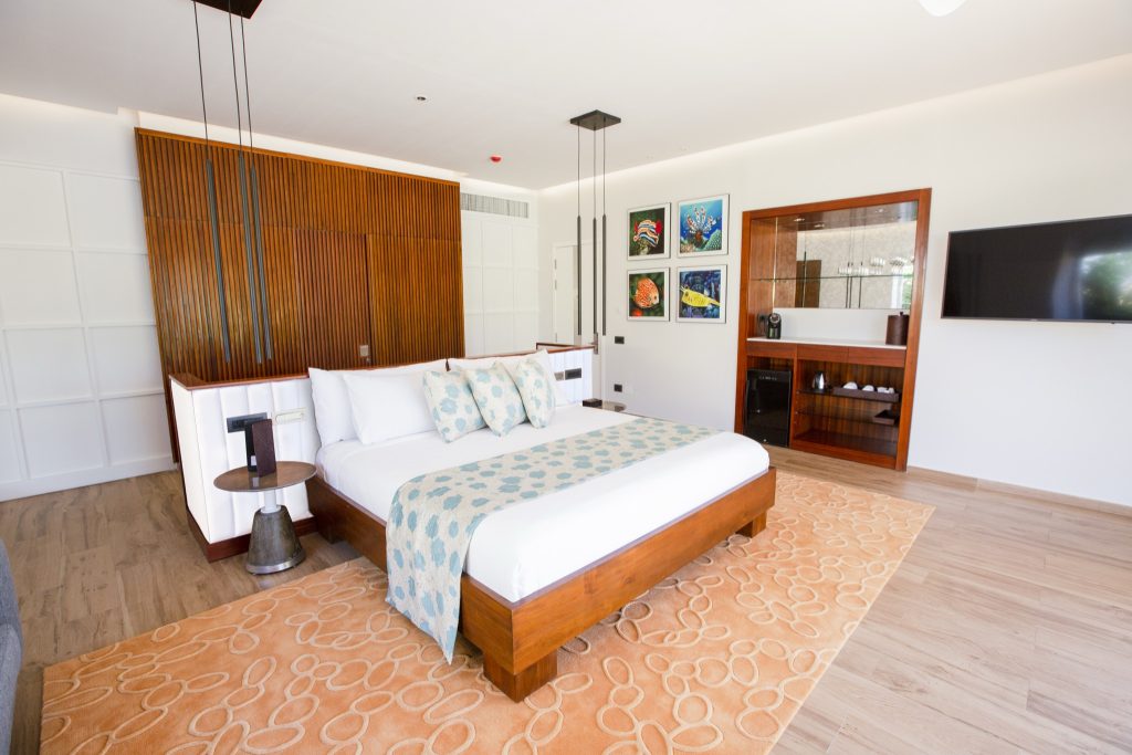 Modernes Hotelzimmer Beach Villa with Pool mit großem Holzrahmenbett, Holzwand und integriertem Fernseher