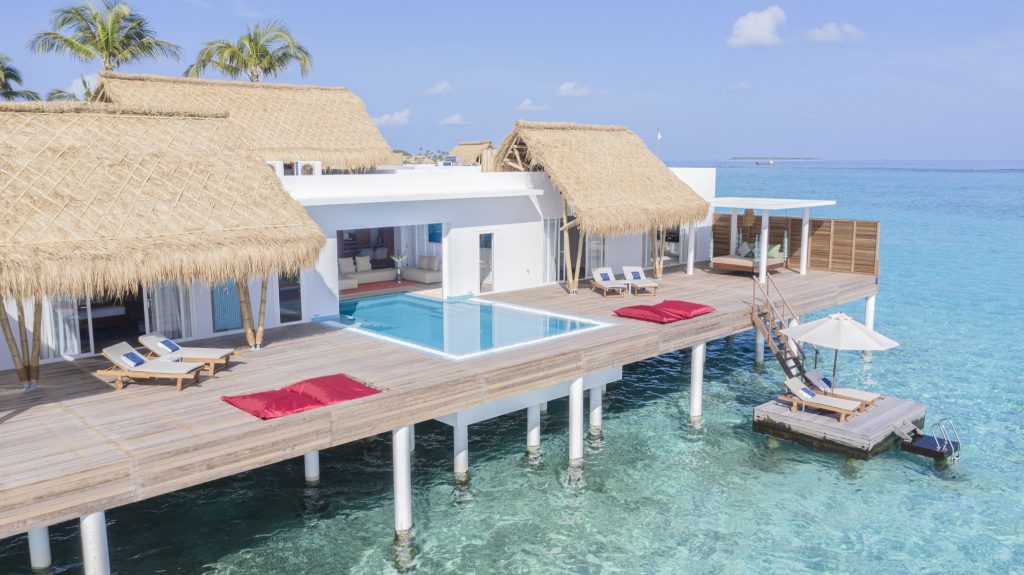 Überwasser-Bungalow Presidential Water Villa mit Holzterrasse, Pool, Liegestühlen und Strohdach auf den