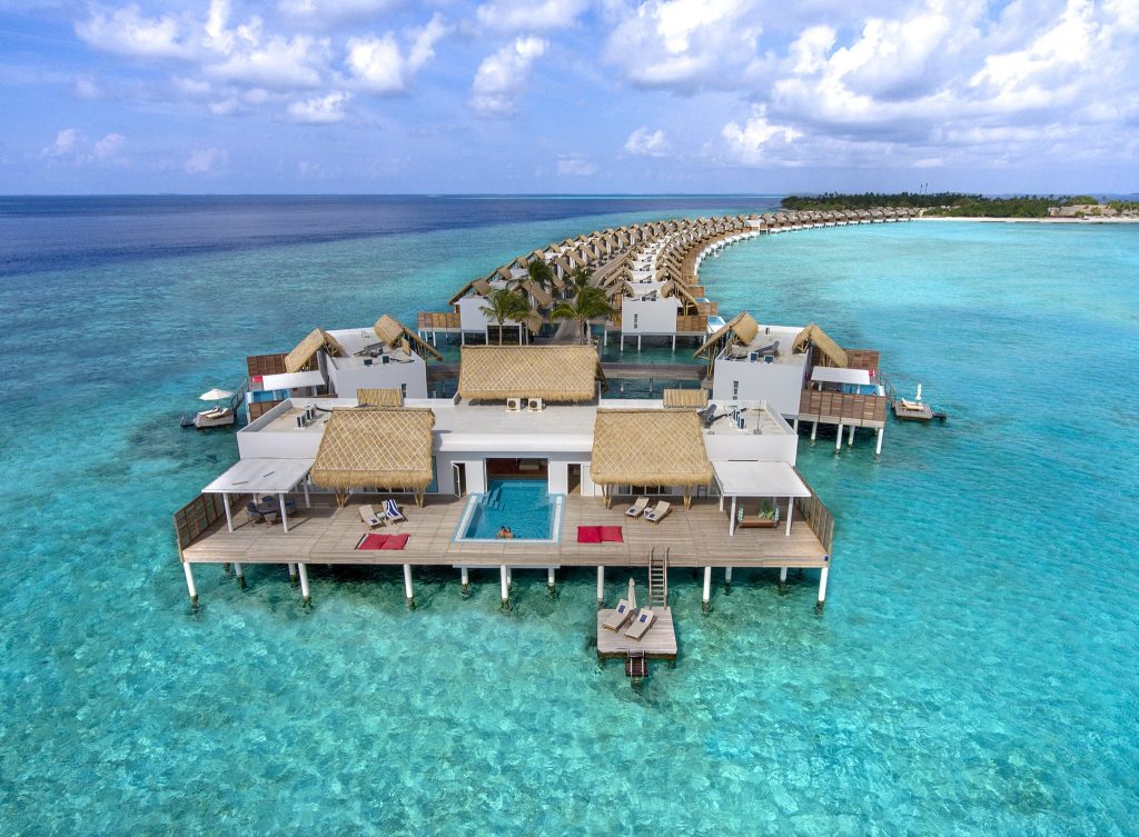 Reihe von Presidential Water Villas auf Stelzen im türkisfarbenen Wasser des Emerald Maldives Resort & Spa