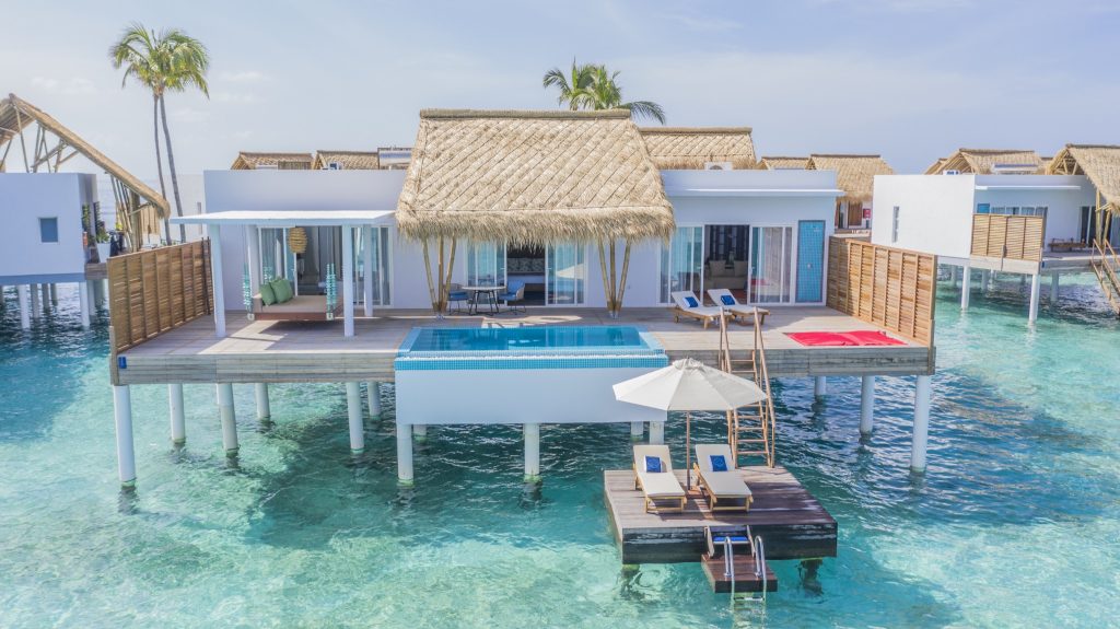 Superior Water Villa mit Terrasse, kleinem Pool, weißen Wänden, Strohdach und Holzschutzwänden über türkisfarbenem Wasser