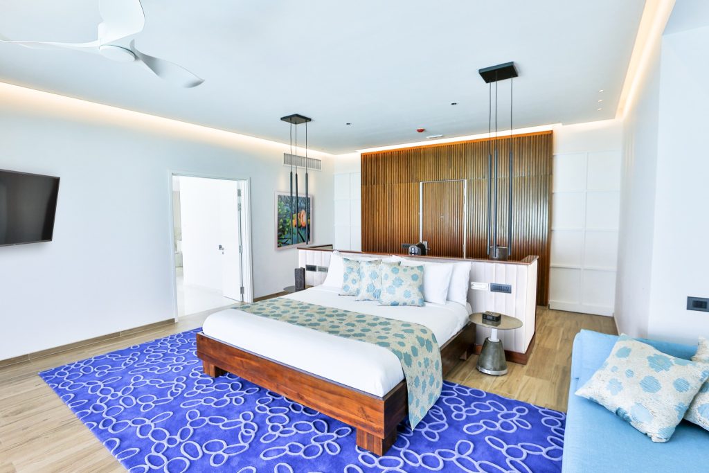 Modernes Hotelzimmer Water Villa with Pool im Emerald Maldives Resort & Spa mit Holzbett.