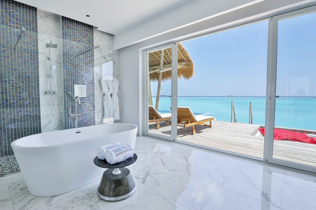 Badezimmer in Water Villa mit freistehender Badewanne, Marmorboden, Mosaikfliesen und Terrasse mit Meerblick Malediven