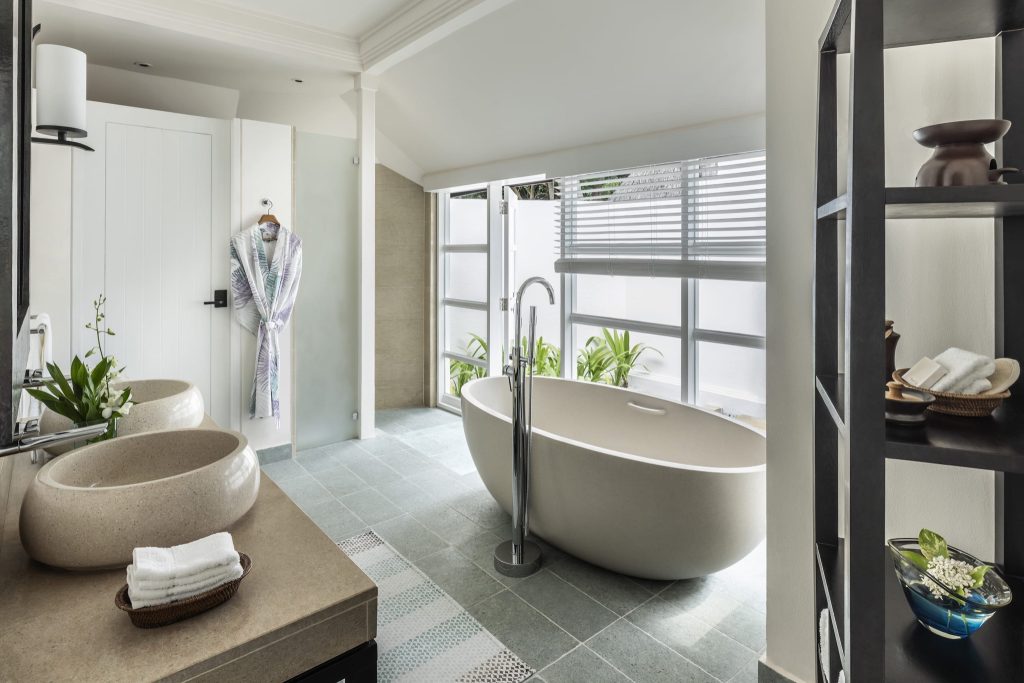 Modernes Badezimmer mit freistehender Badewanne, zwei runden Waschbecken, Pflanzen und großem Fenster im Four Seasons Resort.