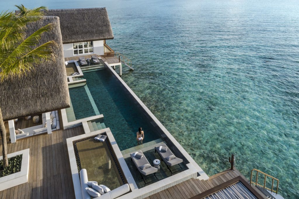Villa am Meer mit rechteckigem Infinity-Pool, Holzdeck und flachem Strohdach in den