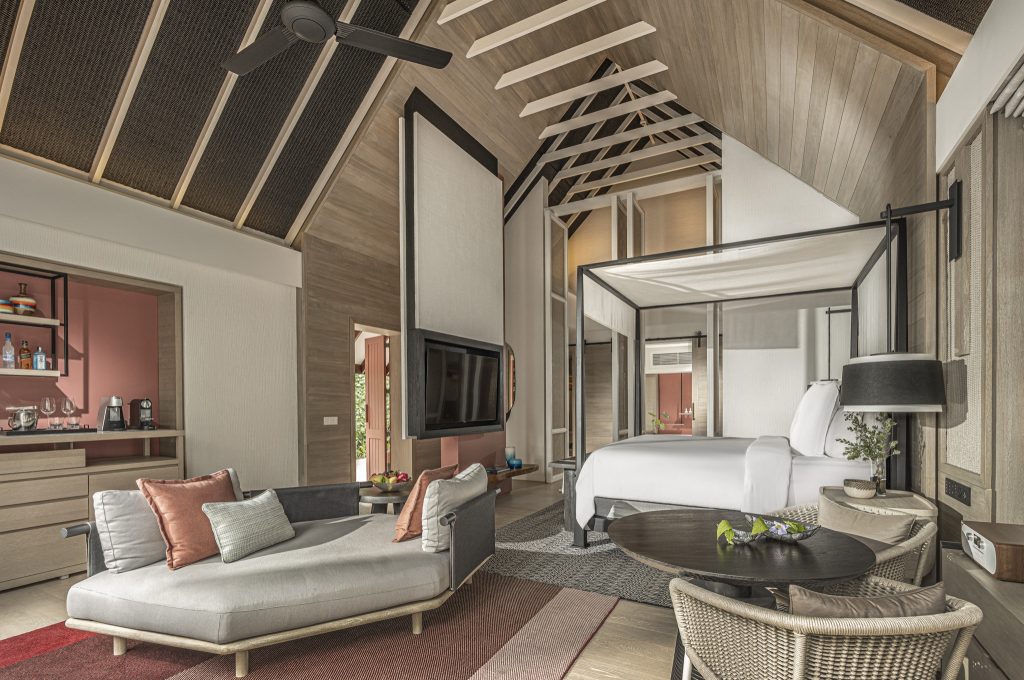 Hotelzimmer mit Himmelbett, Sofaecke, Holzdach, Flachbildfernseher und kleiner Küchenzeile in Rosa