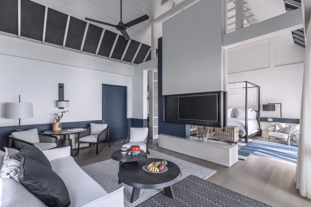 Moderner Hotelraum mit Sofas, Holzmöbeln und Himmelbett im Four Seasons Resort Maldives at Landaa Giraavaru
