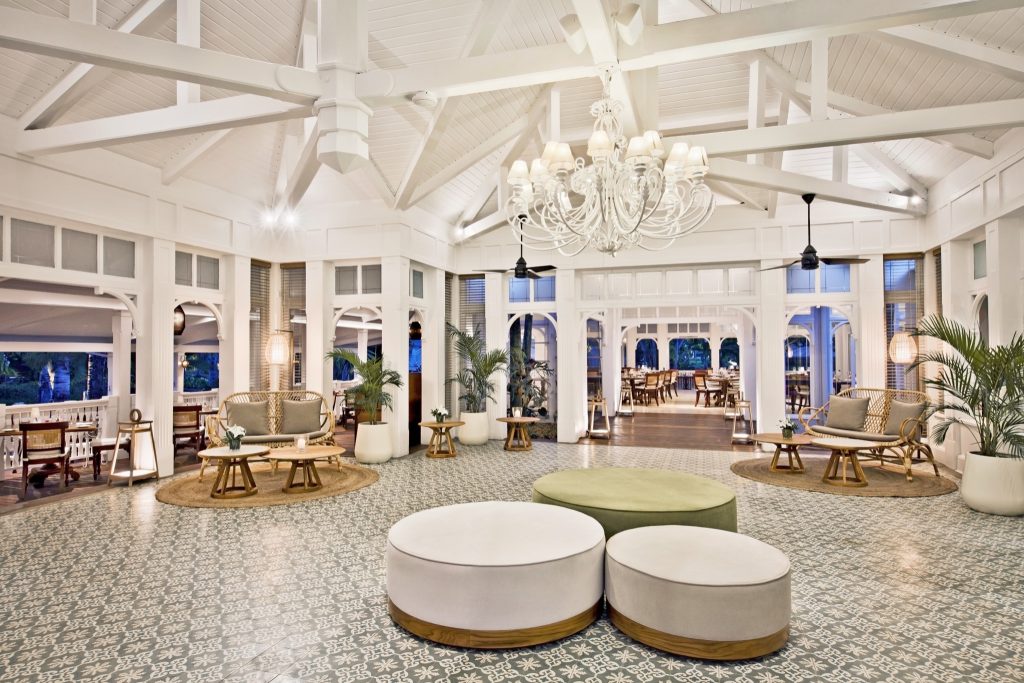 Geräumige Lobby mit weißem Holzdecke, großem Kronleuchter, weißen und grünen Sitzgelegenheiten im Restaurant Annabellas