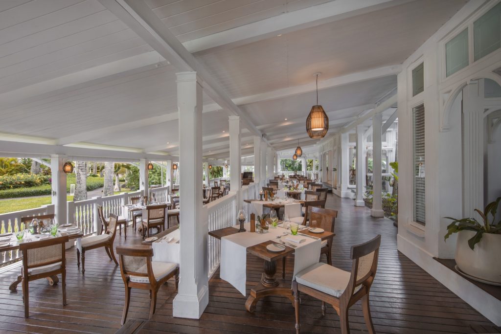Überdachte Terrasse im Restaurant Annabellas mit weißen Tischdecken und Holzmöbeln bei Heritage Le Telfair
