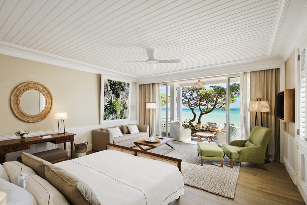 Deluxe Beachfront Suite Zimmer mit Blick aufs Meer, Holzmöbeln, hellem Tageslicht und grünen Akzenten