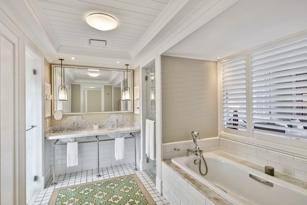 Badezimmer der Deluxe Beachfront Suite im Heritage Le Telfair mit Badewanne, Doppelwaschbecken