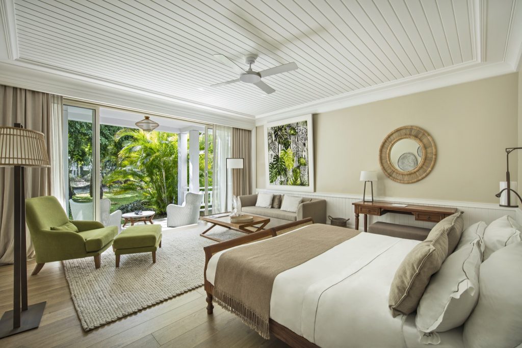 Helles Heritage Le Telfair Deluxe Suite Garden Zimmer mit großem Bett, grünem Sessel und Sofa
