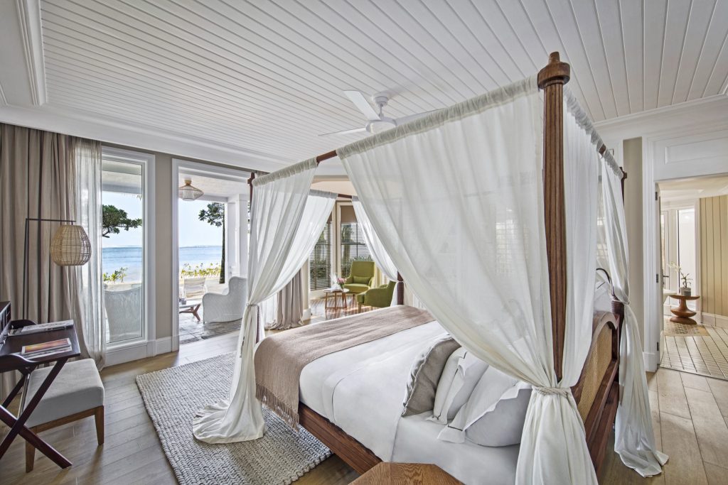 Junior Suite Beach Front Zimmer mit Himmelbett, weißen Vorhängen, Holzboden und Meerblick in Heritage Le Telfair Mauritius