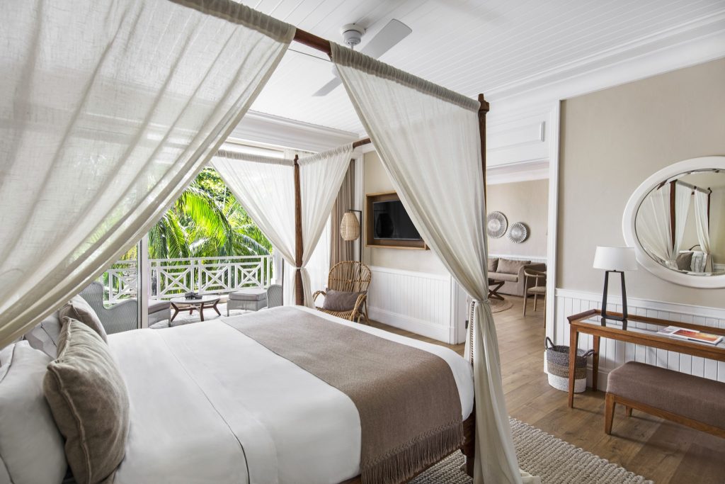 Senior Suite Garden View mit Himmelbett, weißen Vorhängen, Holzfußboden und Balkon mit Gartenblick