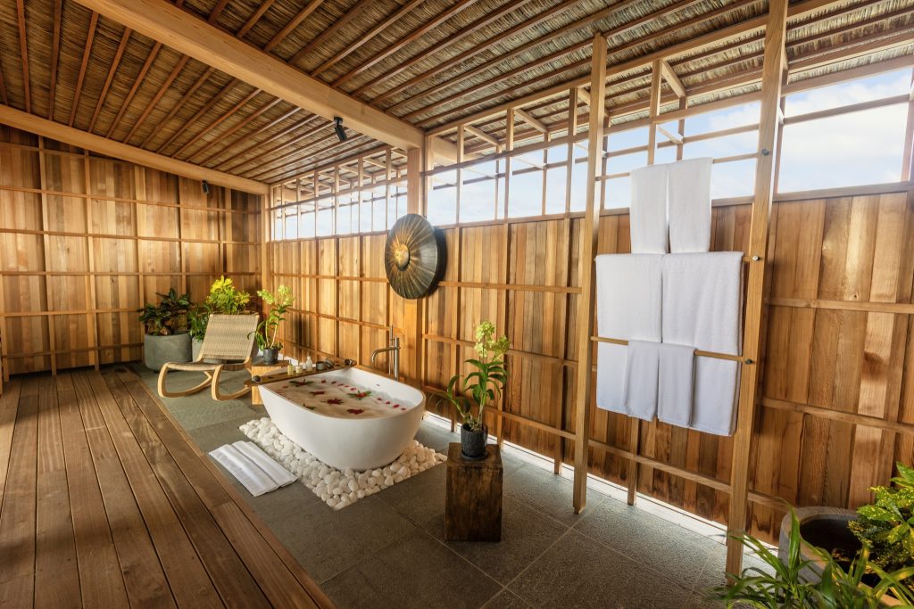 Badezimmer der One Bedroom Residence mit freistehender Badewanne, Holzverkleidung und Tageslicht auf Kudadoo Private Island